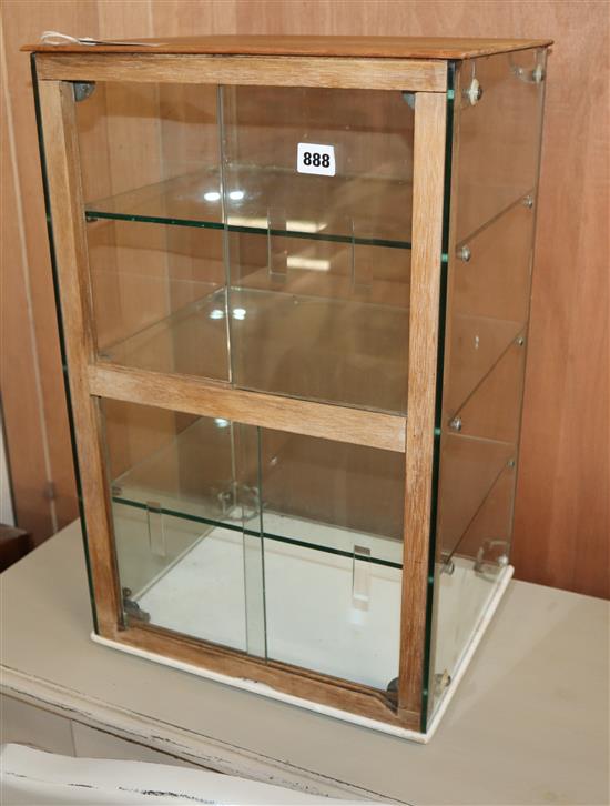 A small glass display cabinet with sliding doors